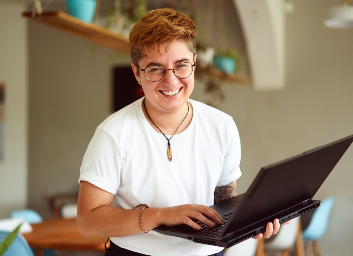 Person smiling holding a laptop