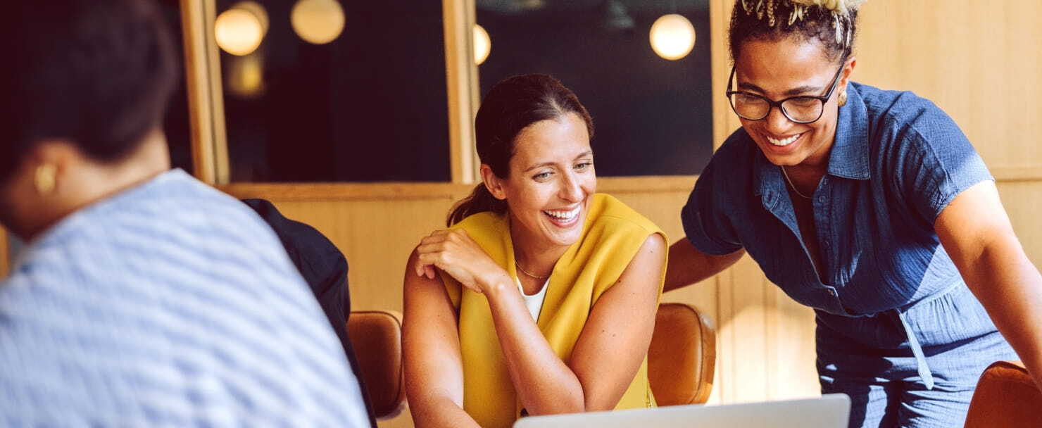 Coworkers smiling looking at laptop