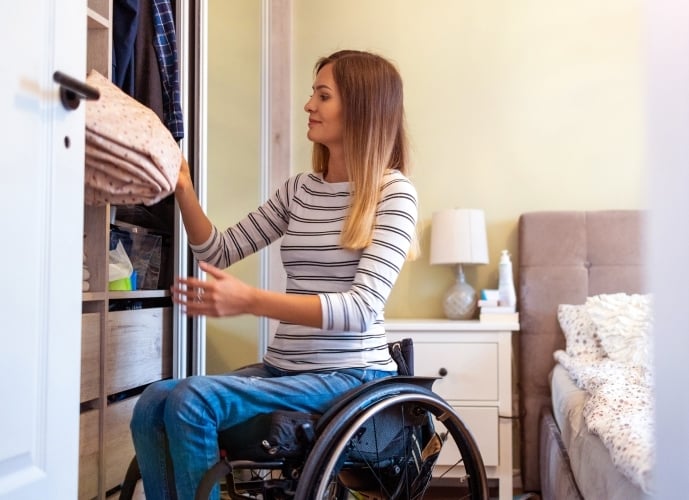 Wheelchair user in bedroom
