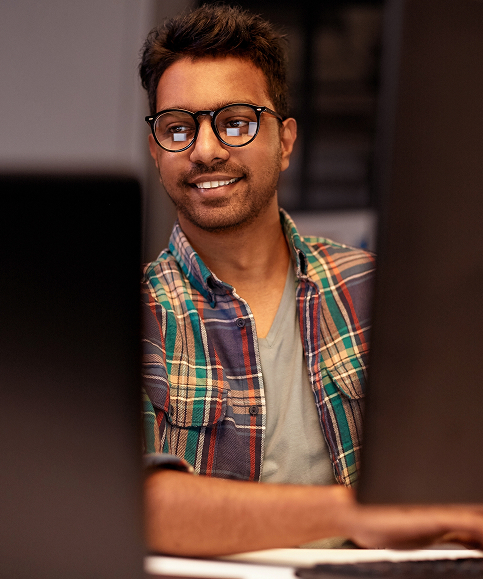 About-Carousel-Looking-Through-Two-Monitors-At-The-Face-Of-A-Young-Worker